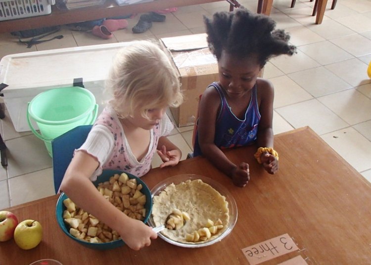 Carefully filling the bottom crust with sugar and cinnamon coated apples!